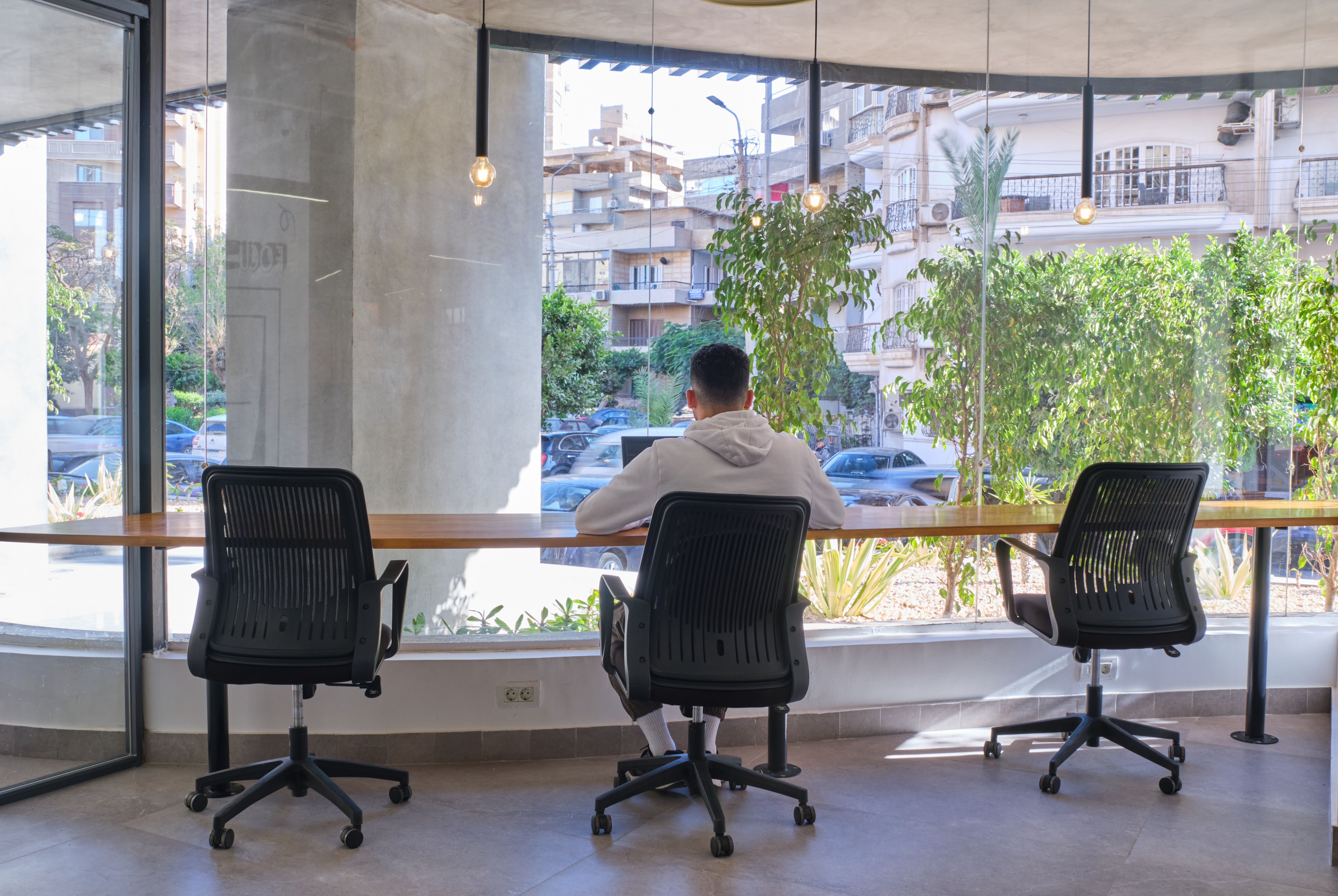 Shared spaces at Coworker, in front of glass windows.